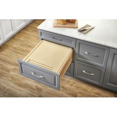 an open drawer in the middle of a kitchen counter with a cutting board on it