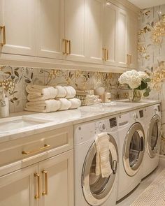 a washer and dryer in a room with flowers on the counter top next to each other