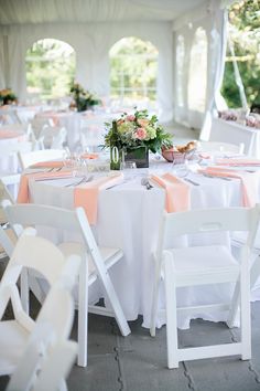 the tables are set up with white chairs and pink napkins on them for an elegant wedding reception