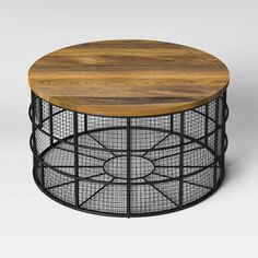 a round wooden table with wire mesh around the top and bottom, on a white background