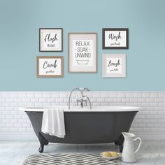 a bathroom with blue walls and pictures on the wall above the claw foot bathtub