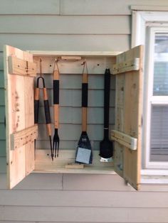 an open wooden box with gardening tools in it