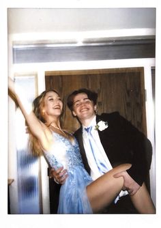 a man and woman are posing for a photo in front of a door with their arms around each other