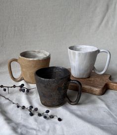 three coffee cups sitting on top of a wooden tray