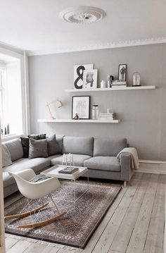 a living room with white walls and grey furniture on the bottom right hand corner is an instagram post