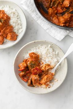 two white bowls filled with rice and meat