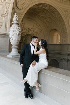 a bride and groom posing for a photo in front of an ornate archway at the san francisco city hall