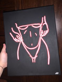 a drawing of a person with headphones on is being held up by someone's hand