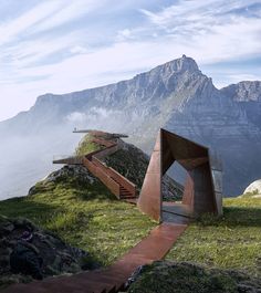 a wooden structure sitting on top of a lush green hillside next to a mountain range