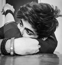 black and white photograph of a young man with his arm resting on the table