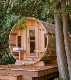 a wooden sauna in the woods surrounded by trees