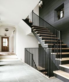 a black and white staircase with wooden handrails