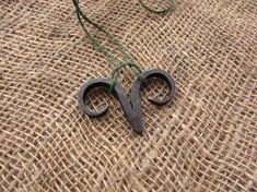 two pairs of scissors sitting on top of a piece of burlied fabric next to a string