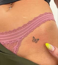 a woman's stomach with a butterfly tattoo on her left side ribcage