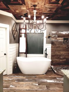 a bath tub sitting under a chandelier in a bathroom