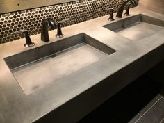 two sinks in a public restroom with tiled walls