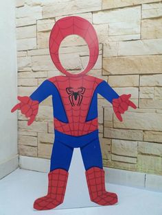 a paper cut out of a spider man standing in front of a brick wall