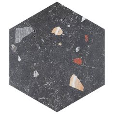 a black hexagonal object with different colored pieces of paint on it's surface