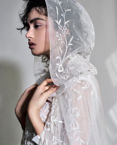 a woman wearing a veil with flowers on it