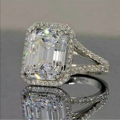 an engagement ring with a large diamond in the center and two rows of pave diamonds around it