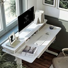 an office desk with a computer on top of it next to a chair and potted plant