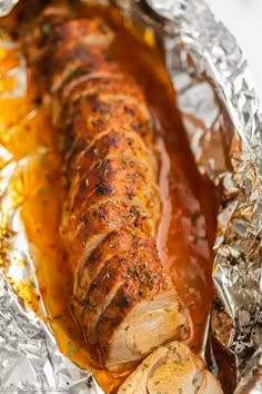 pork loin wrapped in foil with sauce on top