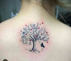 a woman's back with a tree and hearts tattoo on her left side shoulder