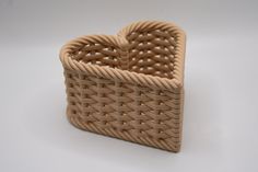 a heart shaped basket sitting on top of a white table