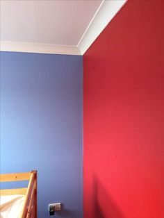 a bedroom painted in red and blue with a bed