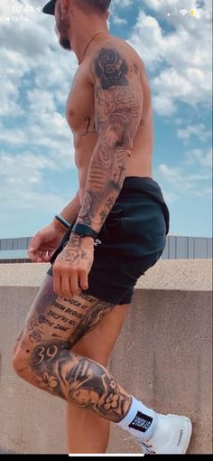 a man with tattoos on his legs and leggings