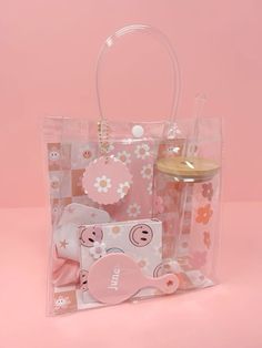 a clear plastic bag with pink flowers and other items in it on a pink background