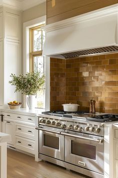 a stove top oven sitting inside of a kitchen next to white cabinets and counter tops