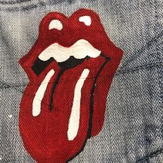 the rolling stones tongue patch is on someone's jean jacket, which has been painted with white paint