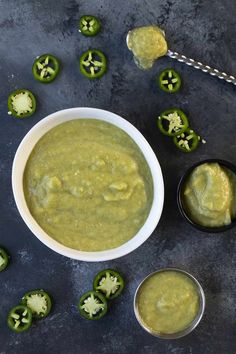 a white bowl filled with green sauce next to some sliced jalapenos