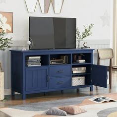 a living room with a large tv on top of a blue entertainment center