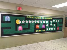 a bulletin board with pacman and other game characters on it in a school hallway