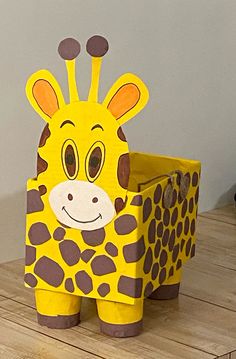 a cardboard giraffe sitting on top of a wooden table