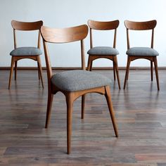 four wooden chairs sitting on top of a hard wood floor