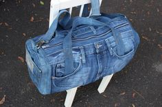 a blue denim bag sitting on top of a white chair next to a black floor