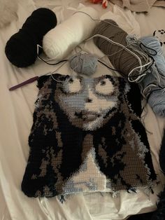 there are many balls of yarn and crochet on the bed with it's face