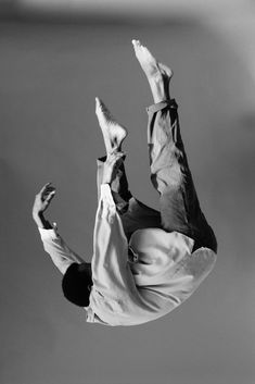 black and white photograph of a man doing a trick on a skateboard in the air