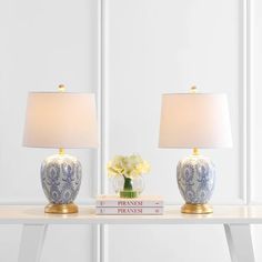 two blue and white vases sitting on top of a table next to a lamp