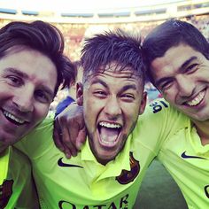 three men are posing for the camera at a soccer game