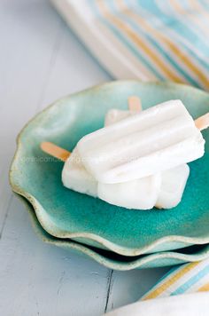 marshmallow pops on a green plate with blue and yellow striped napkins in the background