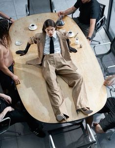 a group of people sitting around a table with a man in a suit on it