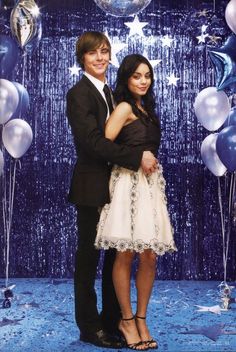 the young couple is posing for a photo in front of blue balloons and streamers