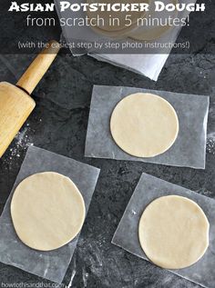 four uncooked pizza doughs sitting on top of wax paper next to a rolling pin