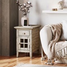 a white couch sitting next to a wooden table on top of a hard wood floor