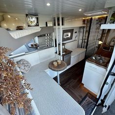 the interior of an rv with wood flooring and white appliances, including stove top oven