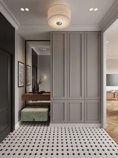 the hallway is decorated in gray and white with black accents on the walls, along with a bench